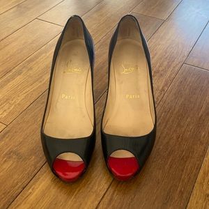 Christian Louboutin black leather heels with red peep toe.
